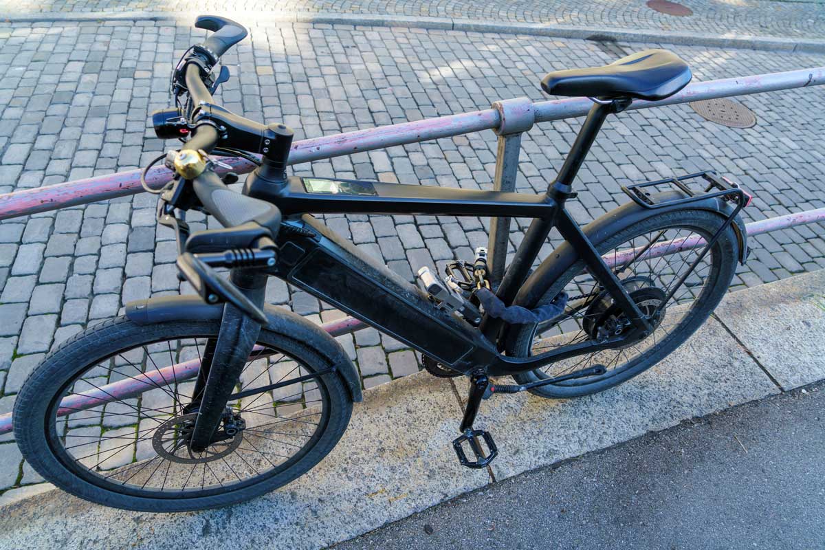 Un vélo électrique attaché avec un antivol à chaîne